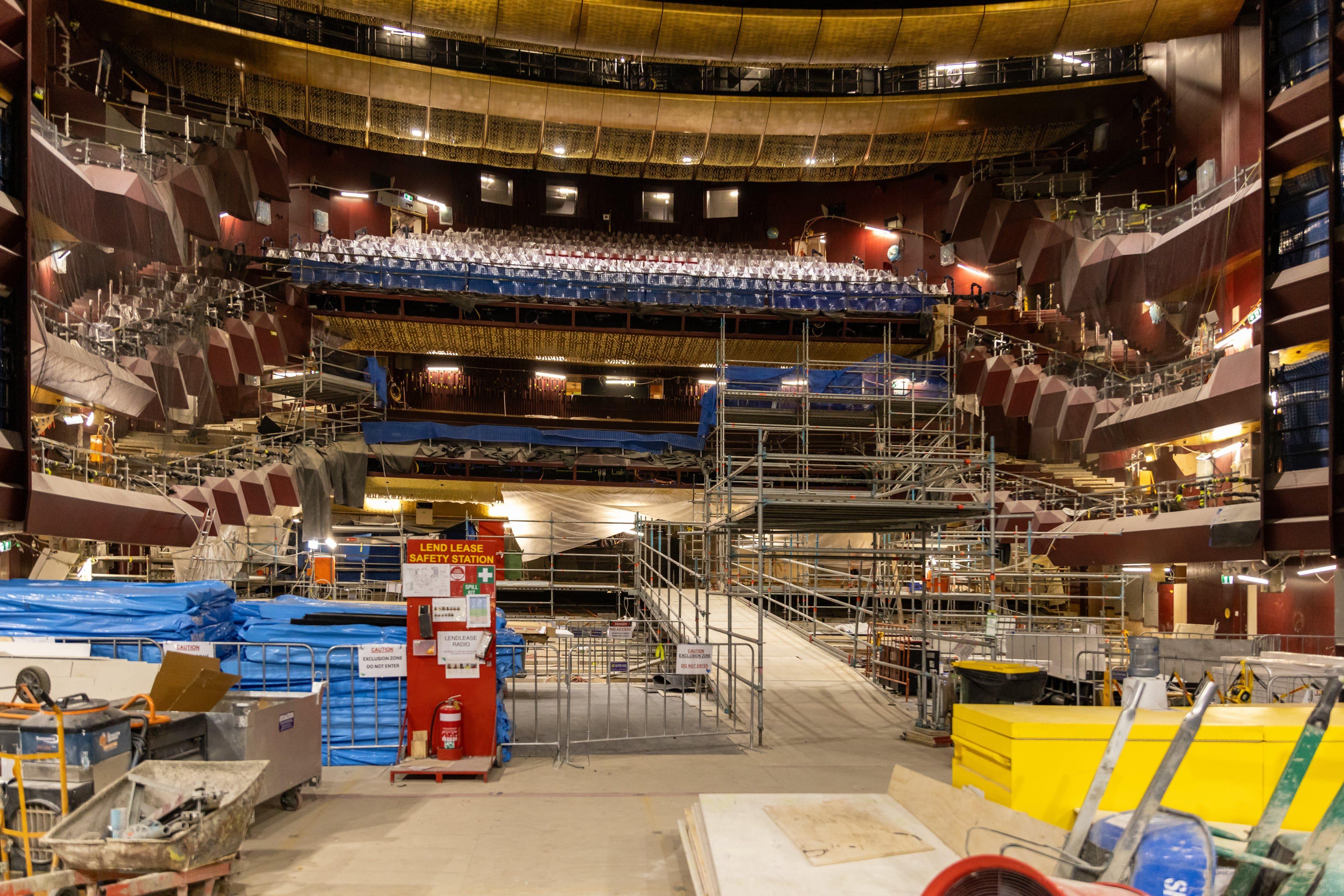 Interior view of the Ian Potter State Theatre showing its ornate ceiling and tiered seating while under construction. Scaffolding and temporary walkways have been put in place throughout the theatre.